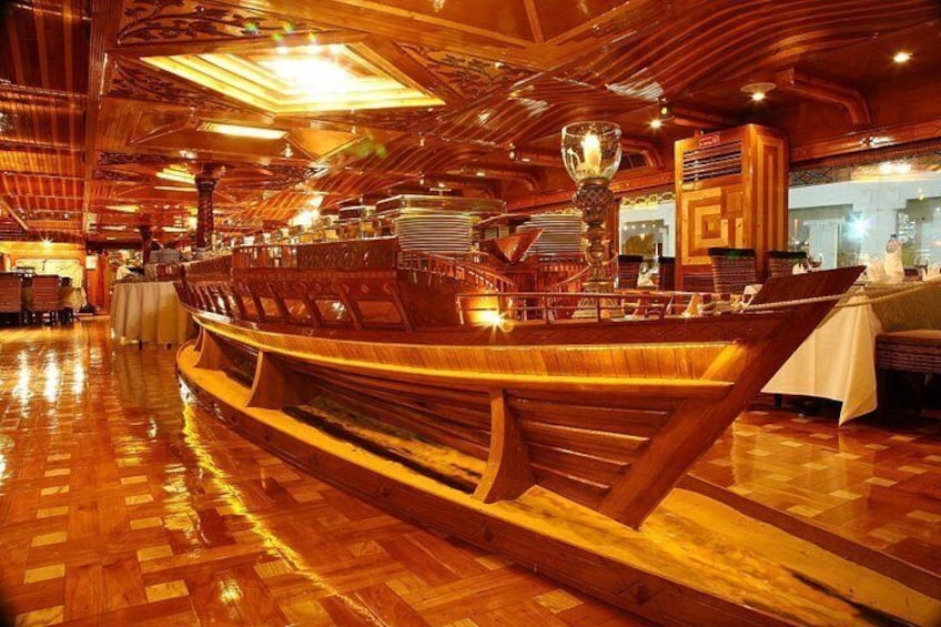 A wooden ship-shaped structure in a restaurant with a polished wooden floor and warm lighting. 4