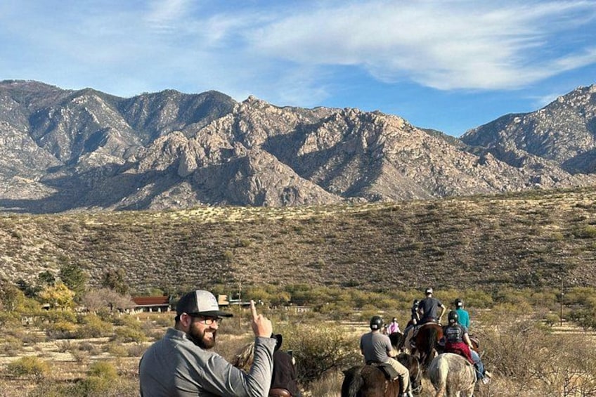 A group of people riding horses across a mountainous landscape. 5
