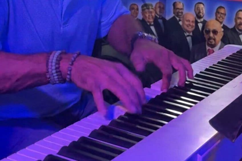 A person playing a keyboard with a blurred audience in the background. 3