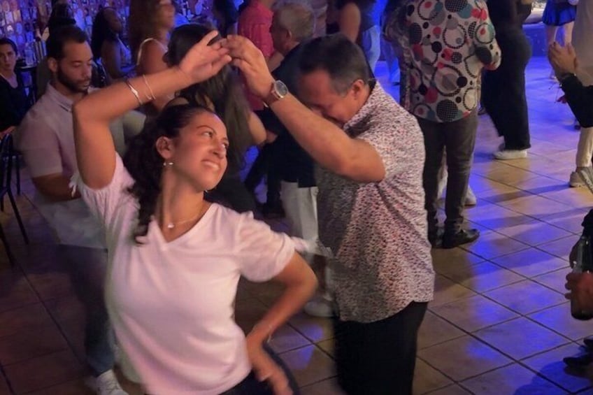 A group of people dancing in a social setting. 4