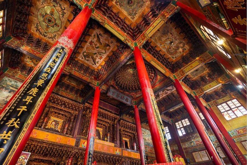 Un intérieur somptueux, orné de motifs complexes sur le plafond, de piliers rouges et d’éléments architecturaux traditionnels d’Asie. 4