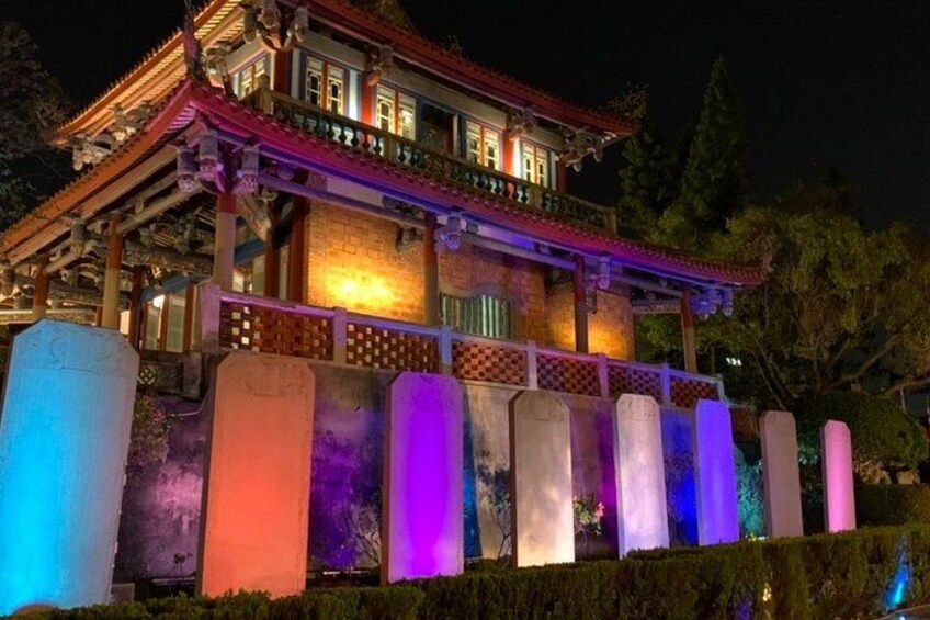 Un bâtiment traditionnel doté de colonnes illuminées et d’un balcon. 2