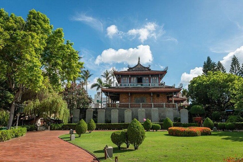 A traditional building with a tiled roof, surrounded by well-maintained greenery and a paved walkway. 4