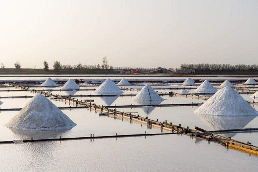 Salt piles in a water body with wooden walkways. 3