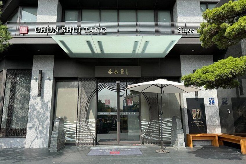 A building with a sign reading 'CHUN SHUI TANG' and a large glass entrance. 3