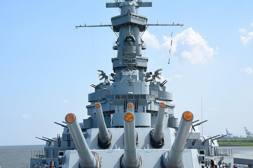 A large naval ship with multiple gun turrets and a superstructure. 3