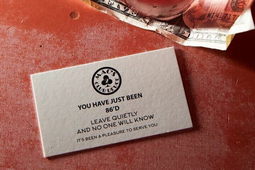 A card with a club logo and text on a wooden surface. 1