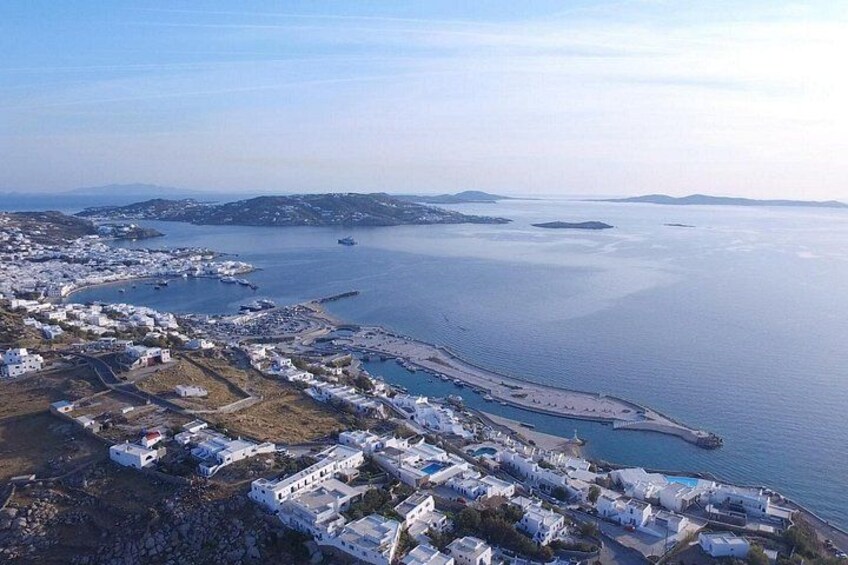 An aerial view of a coastal town with white buildings, a marina, and a large body of water. 2