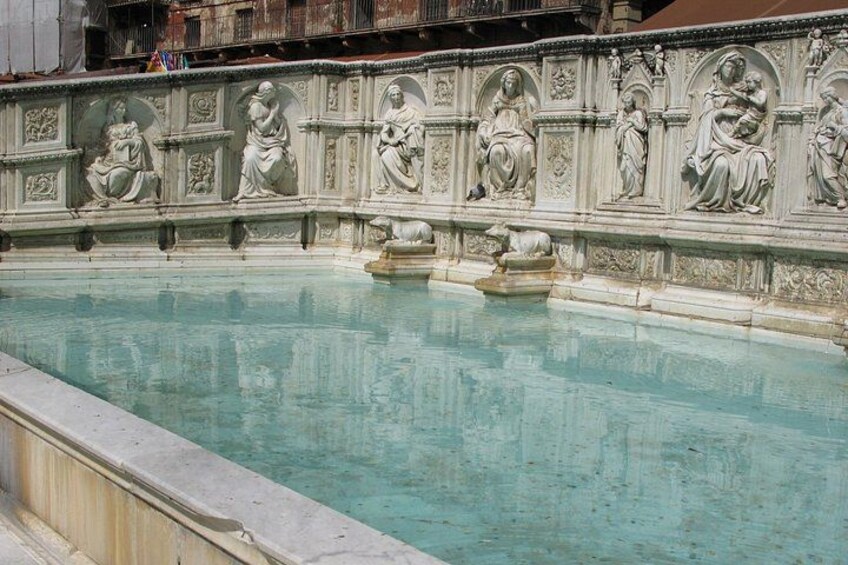 Ein Pool mit Statuen und einer Fontäne. 3