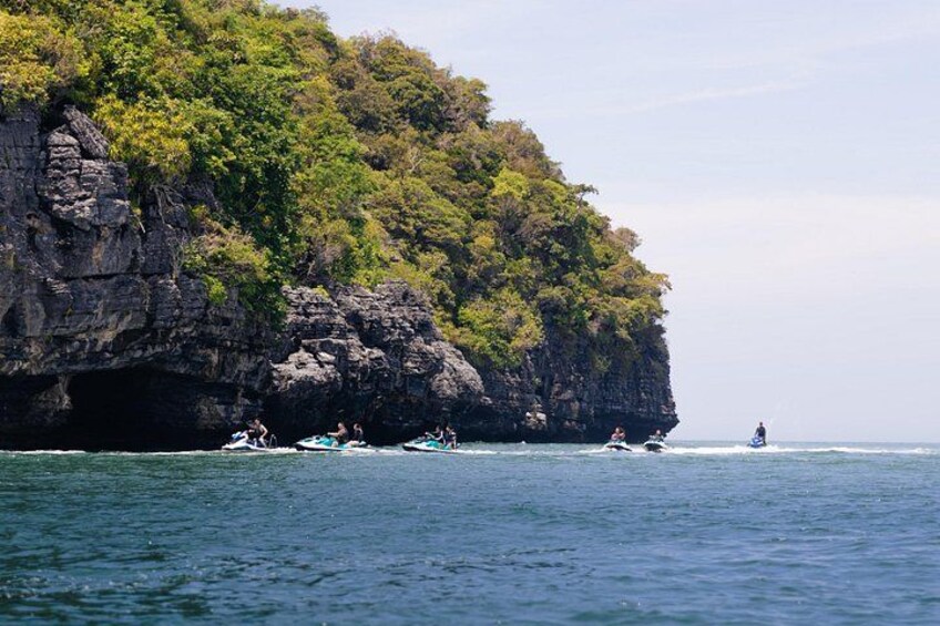 A rocky coastline with boats and a jet ski. 3