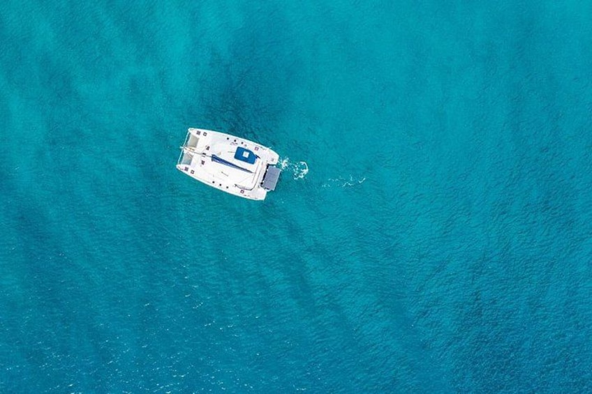 An aerial view of a small boat in turquoise waters. 5