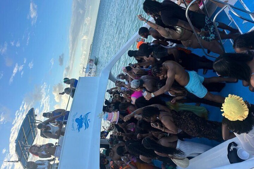A group of people on a boat with a banner reading "Maya Blue Star". 4