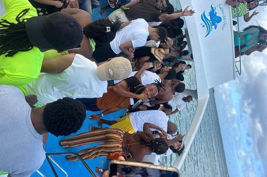 Eine Gruppe von Personen auf einem Boot, erkennbar am Logo an der Seite. 5