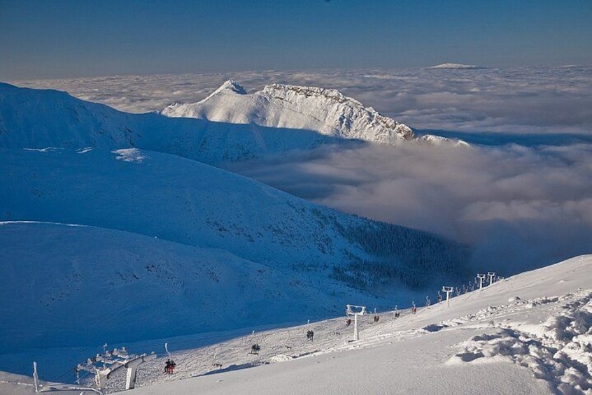 A snow-covered mountain landscape with ski lifts and a clear sky. 3