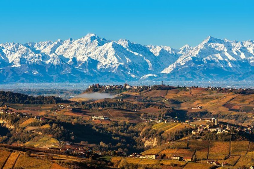 Un paysage montagneux aux sommets enneigés, une vallée parsemée de bâtiments et un ciel dégagé. 2