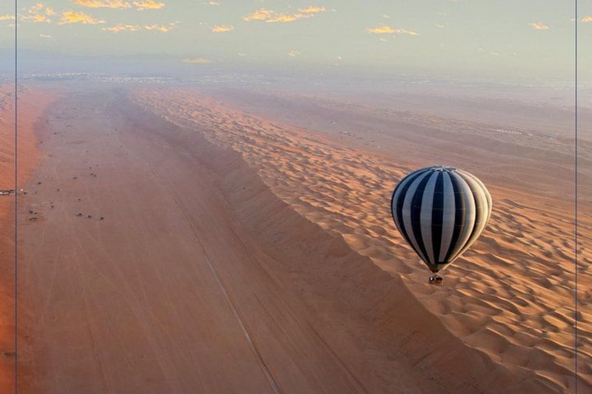 En varmluftsballon over et stort ørkenlandskab med sandklitter. 2