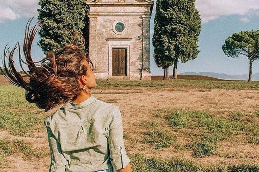 A person standing in a field with a building in the background. 4