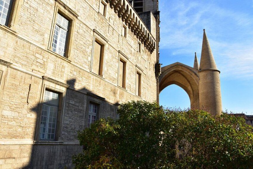 A stone building with a large arched entrance and a tall tower. 2