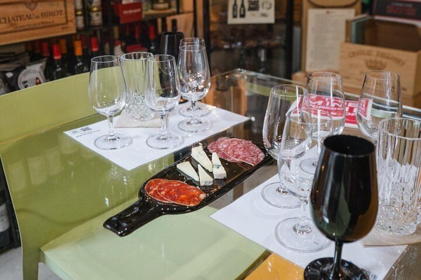 A wine tasting setup with glasses, a wine bottle, and a cheese board. 3