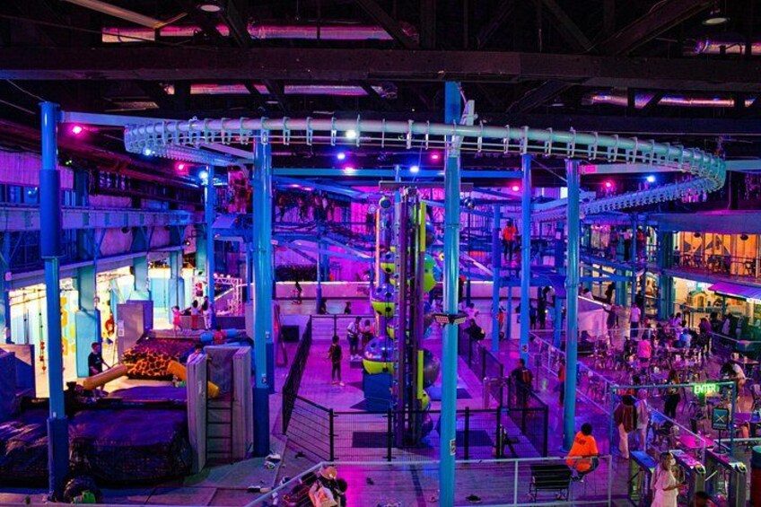 Un parque de atracciones cubierto con montañas rusas, escaleras mecánicas y diversas atracciones. 1