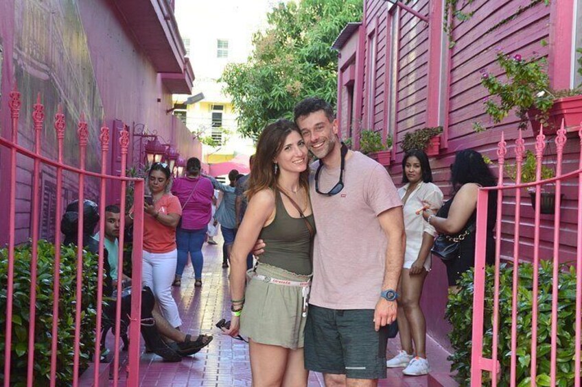 A narrow alley with pink railings, a person in a green dress, and another in a pink shirt. 5
