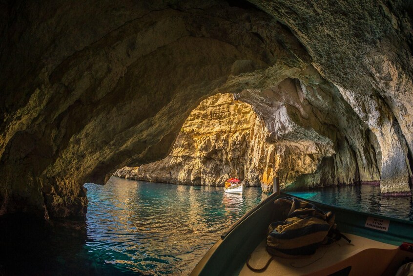 A boat navigating through a cave with a natural arch formation. 4