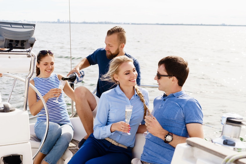 A group of people on a boat, holding champagne glasses. 1