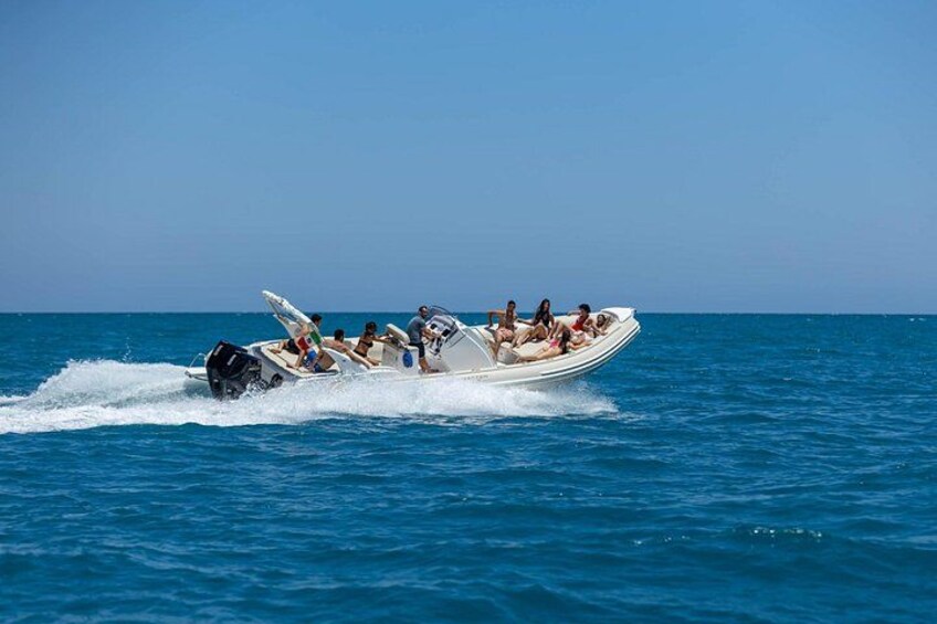 Een speedboot met passagiers op een heldere blauwe zee. 3