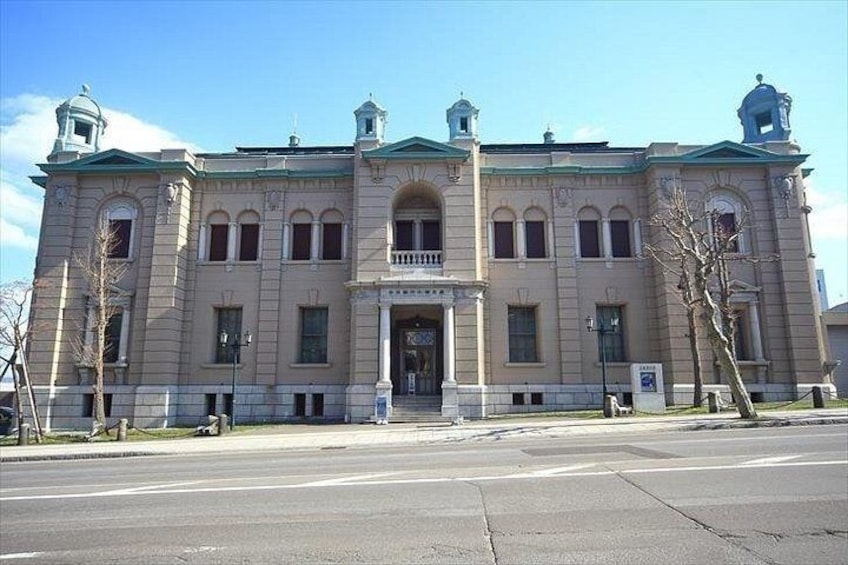 A large, historic building with a symmetrical facade, arched windows, and a central entrance. 5