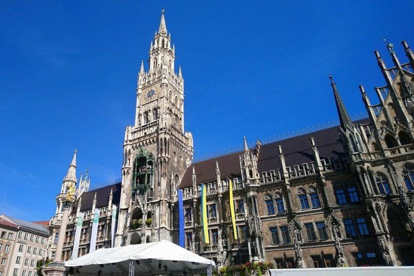 Ein historisches Gebäude mit einem markanten Turm, Flaggen und blauem Himmel. 5