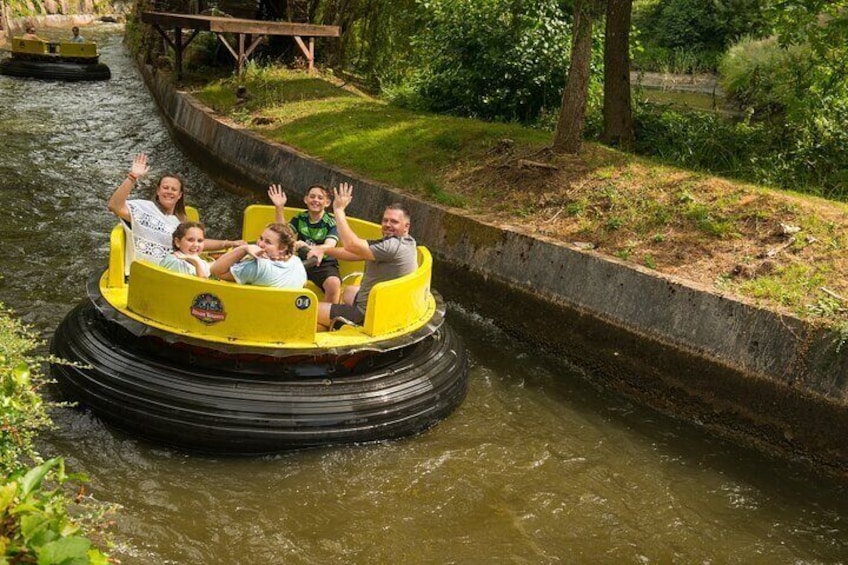 Un groupe de personnes à bord d’un bateau pour une attraction aquatique avec des toboggans jaunes. 2