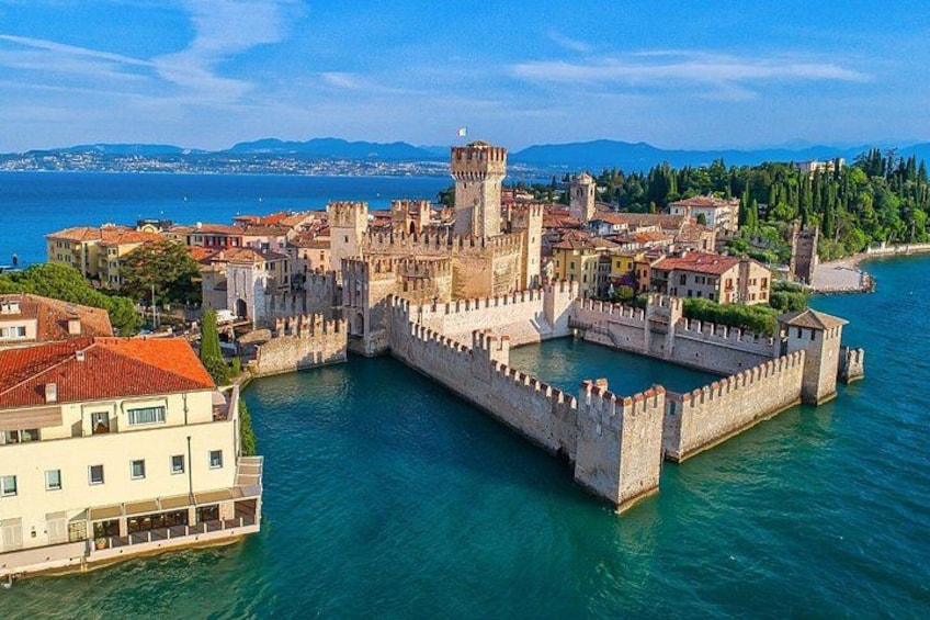 A historic fortified city with a prominent castle, surrounded by water and featuring a mix of traditional and modern architecture. 2