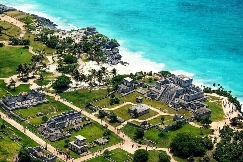 An ancient Mayan city with pyramids and temples near a beach. 1