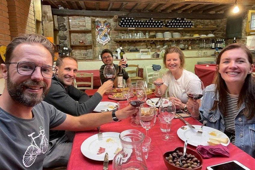 A group of people dining at a restaurant with wine glasses and plates on the table. 2