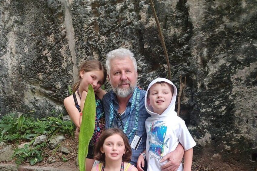A family of four outdoors with a rocky cliff in the background. 5