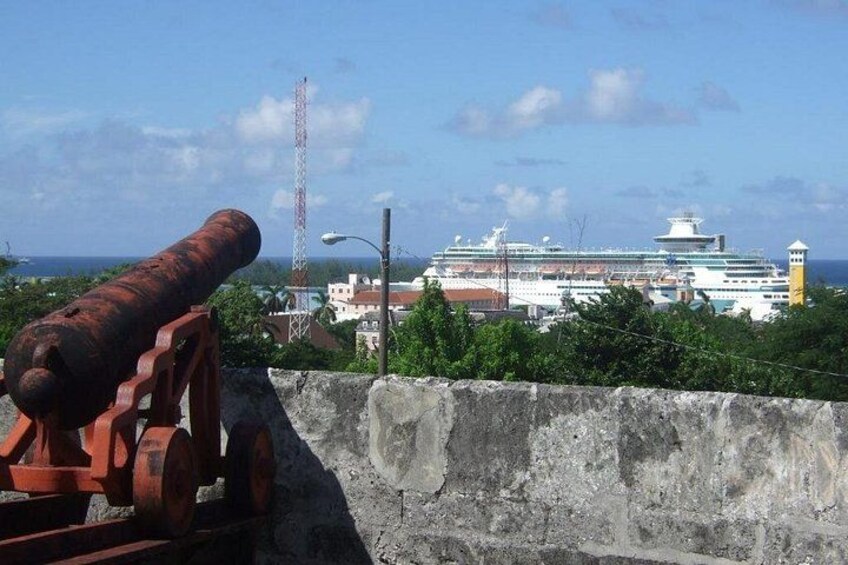 Un gran crucero amarrado en un puerto con un cañón oxidado al frente. 3