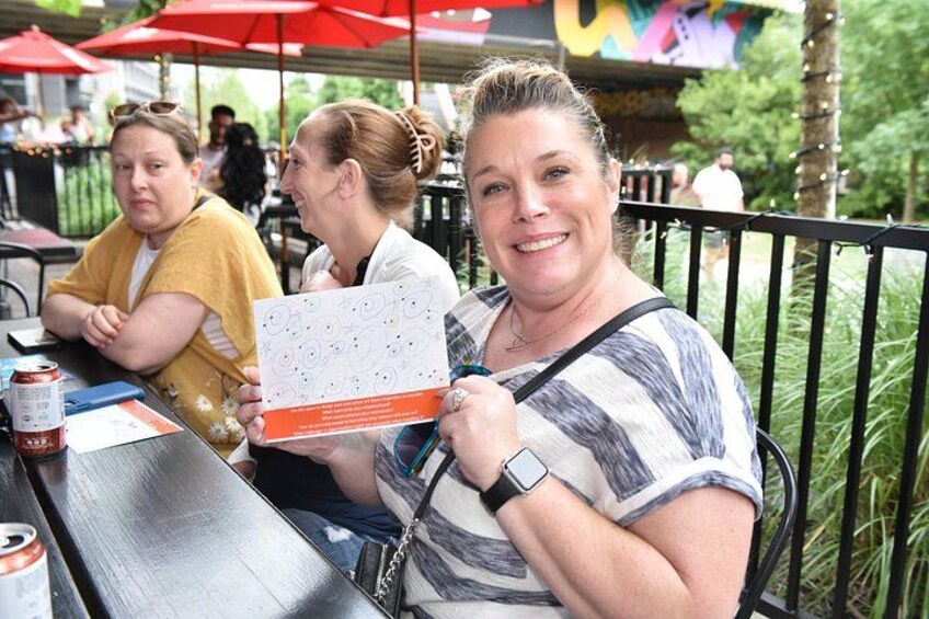 Des personnes sont assises à une table en plein air, devant un menu et avec une boisson. 3