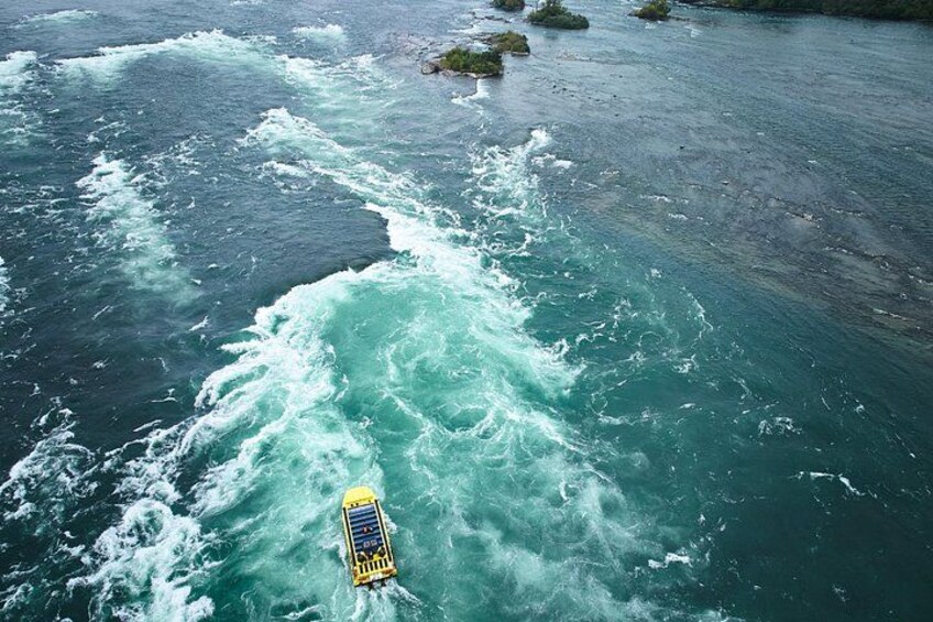 A yellow boat navigating through turbulent waters with waves crashing around it. 5
