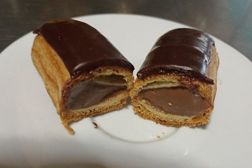 A chocolate-covered pastry on a white plate. 2