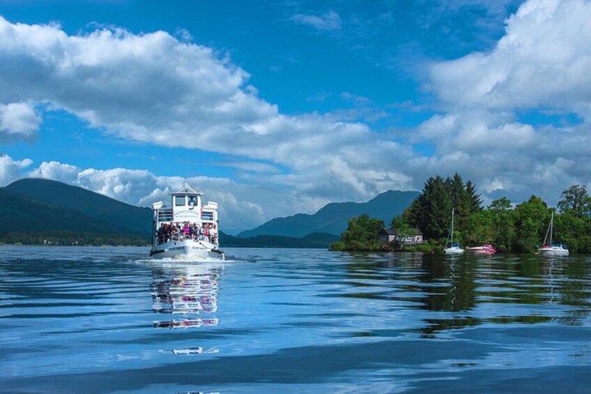 Ein Boot auf einem ruhigen See, im Hintergrund Berge. 5