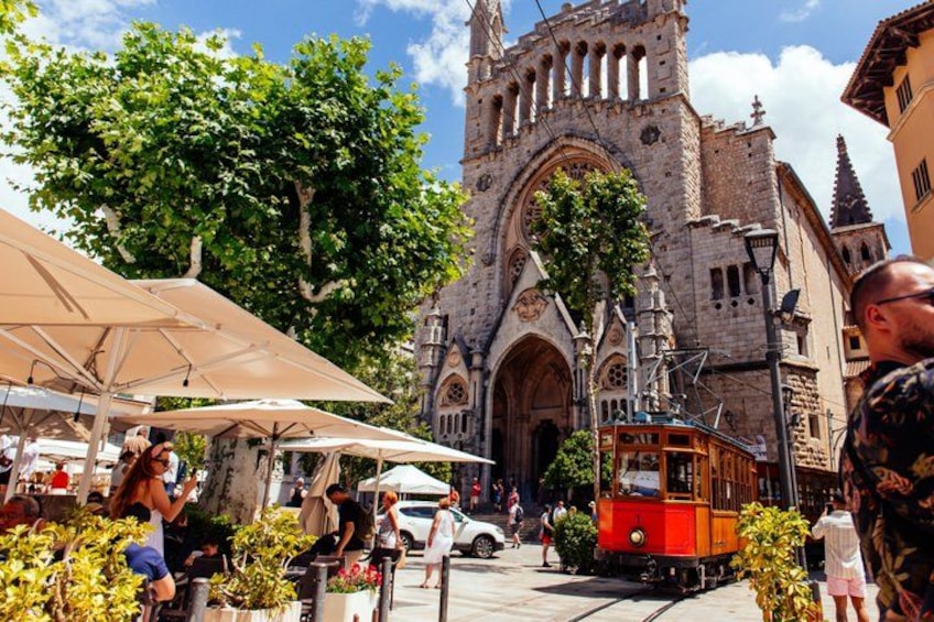 Een historische kerk met een rode tram ervoor. 2