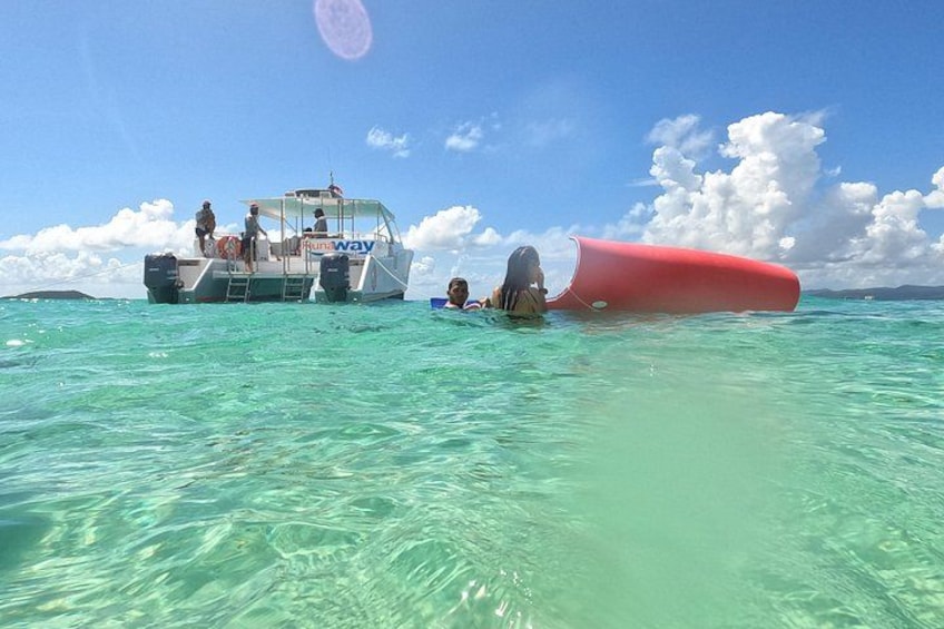 A boat with people on it and a red object in the water. 4