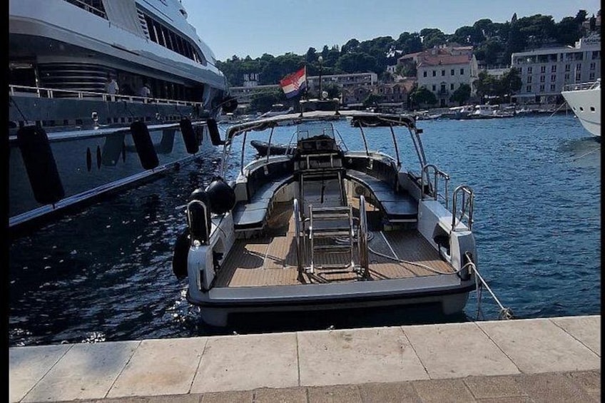 A boat docked at a marina with a cityscape in the background. 3