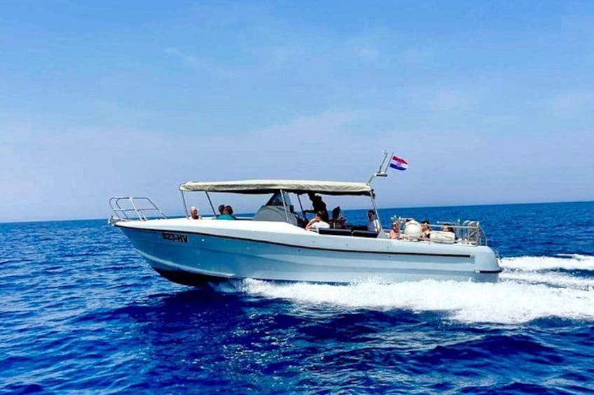 A white motorboat with a flag, moving on a blue sea. 2