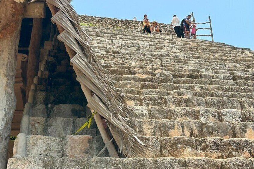 A stone staircase leading up to a building with a thatched roof. 4