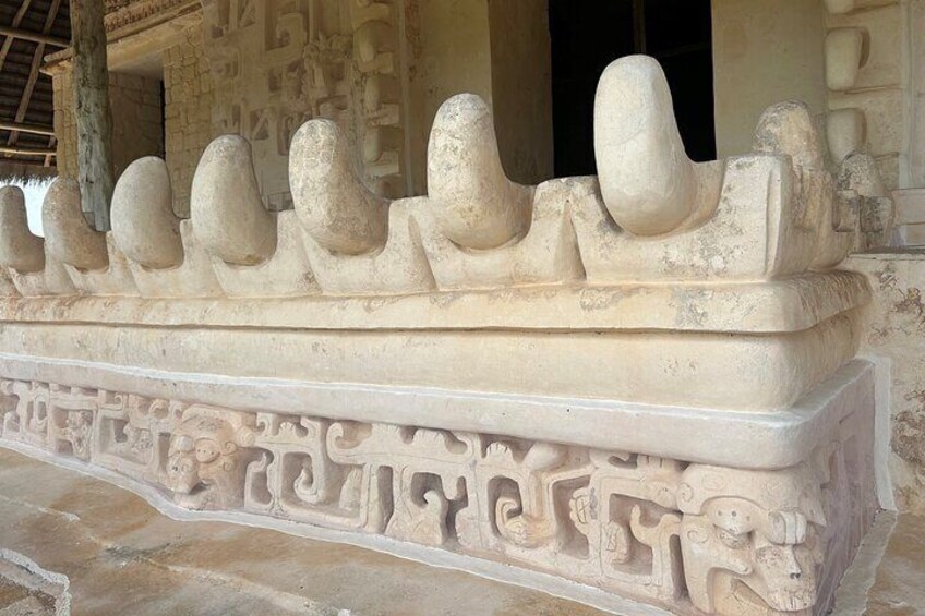 A stone balustrade with carved figures and geometric patterns. 5
