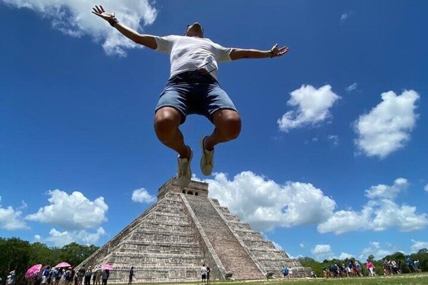 A person jumping off a pyramid with a clear blue sky in the background. 1