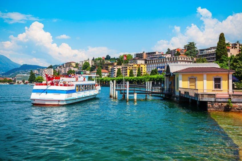 A lake with a boat, a dock, and a cityscape in the background. 2