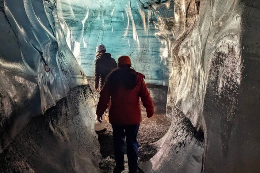 An ice cave with people exploring inside. 2