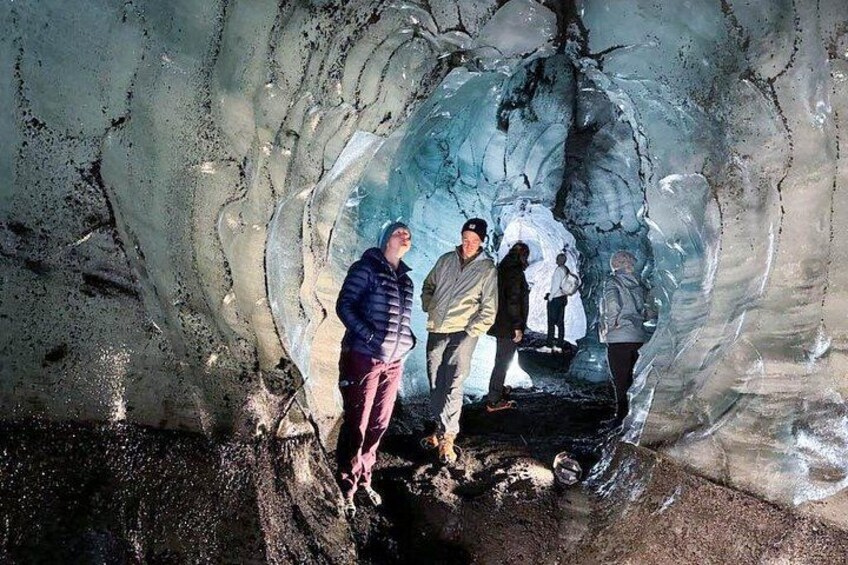 An ice cave with people exploring inside. 4
